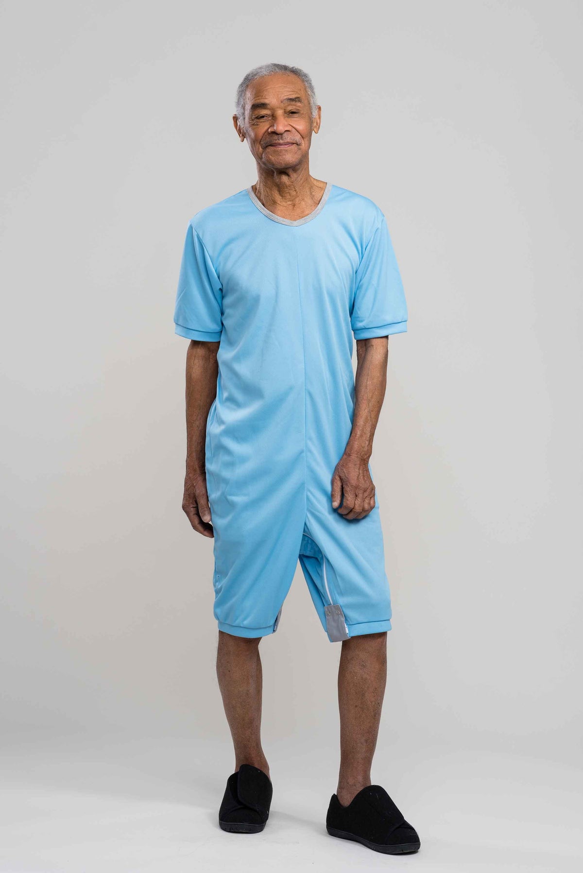 Adaptive short legs onesie designed for people suffering from dementia. A zipper on the back of the garment prevents the wearer from undressing. A large, zippered crotch opening facilitates diaper changes. Durable soft mesh knit dries quickly. Can be wo